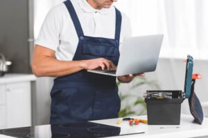 Plumber with Laptop Doing Repair